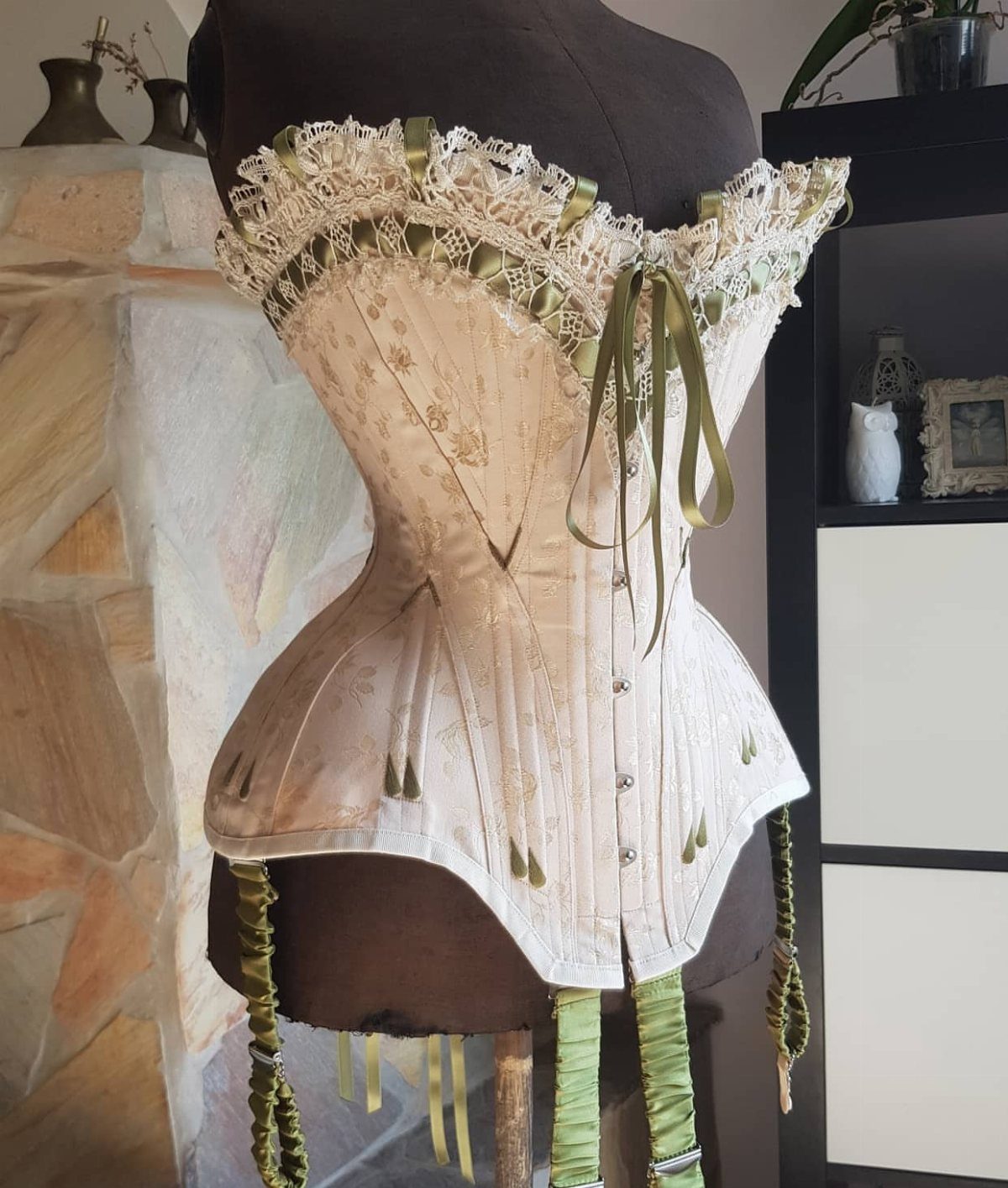16th Century Fashion for Women: 9 Gown and Bodice Ideas 8 Cream and gold corset with green ribbons on a brown mannequin torso.