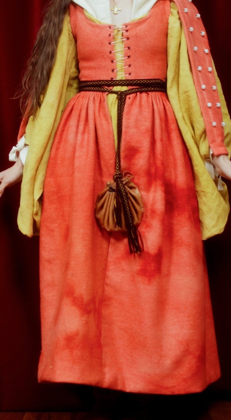 16th Century Fashion for Women: 9 Gown and Bodice Ideas 3 Woman wearing a period orange and yellow 16th century style dress with pouch.