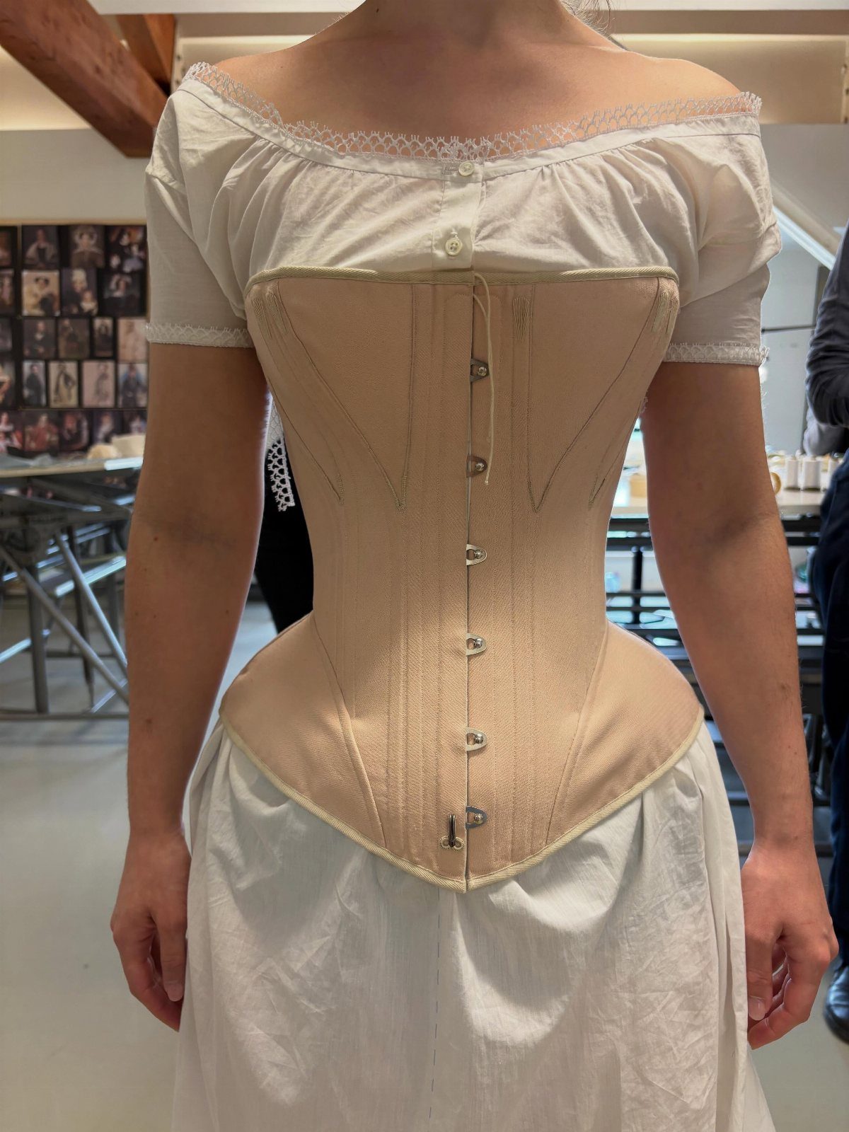19th Century Fashion for Women: 8 Styles and Silhouettes 6 Woman wearing a tan 19th century style corset over a white chemise.