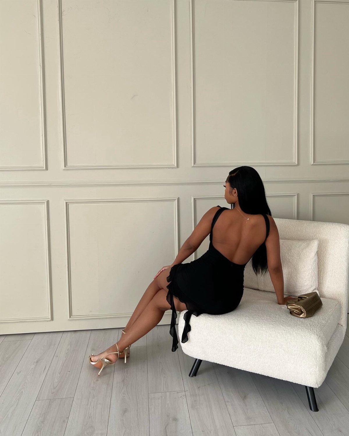 2016 Clubbing Outfits: 14 Ideas from Corsets to Boots 8 Woman in a black minidress and gold heels with a gold sequinned clutch bag.