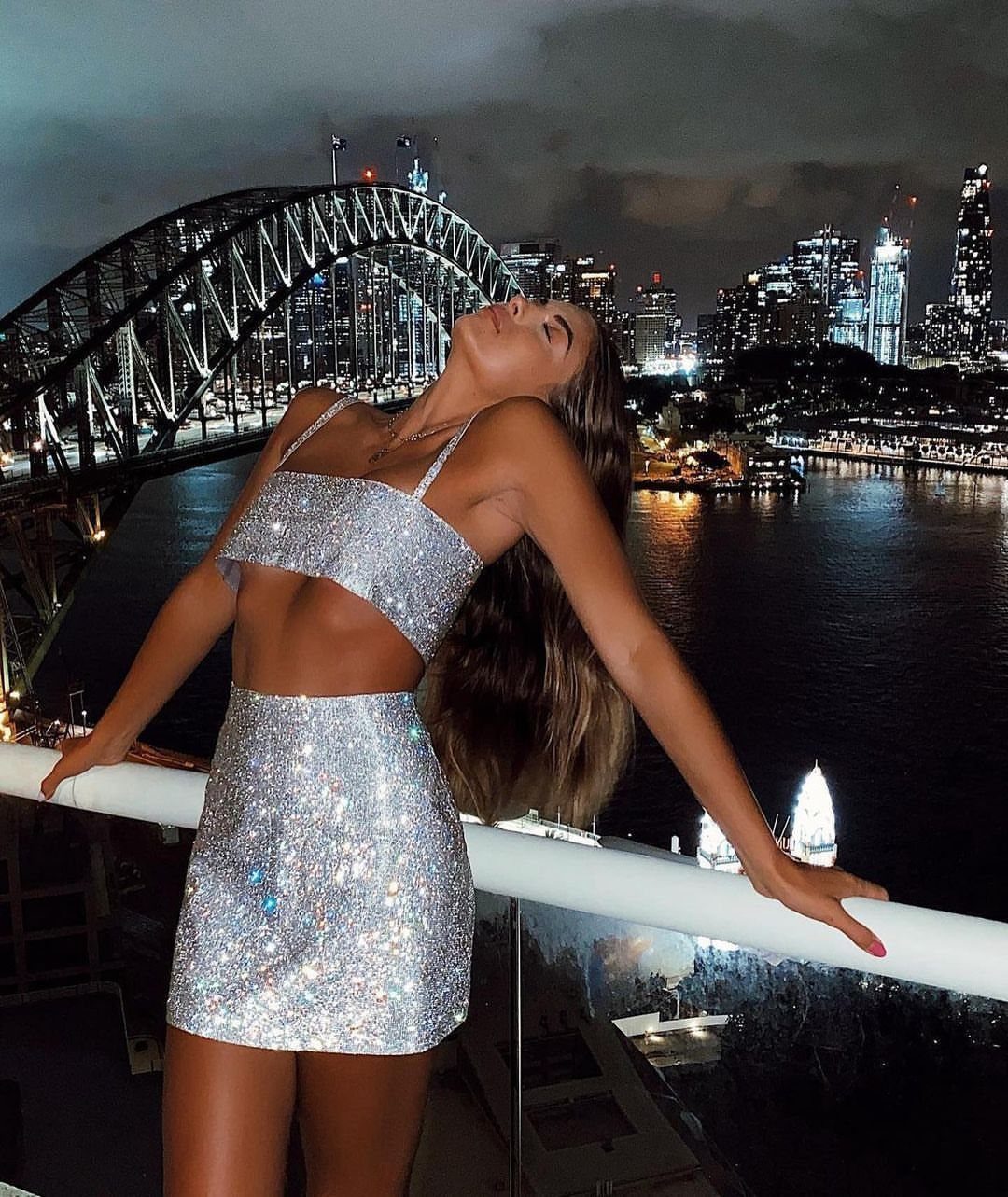 2016 Clubbing Outfits: 14 Ideas from Corsets to Boots 5 Woman in sparkly silver crop top and mini skirt posing before Sydney skyline