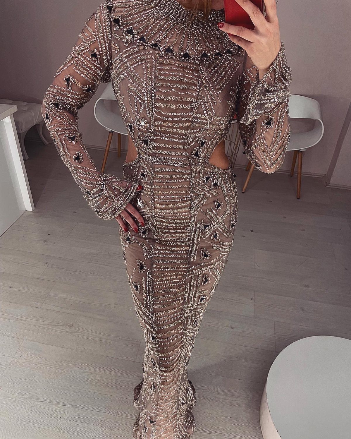 Beaded floor-length beige gown with long sleeves and intricate sequin patterns.