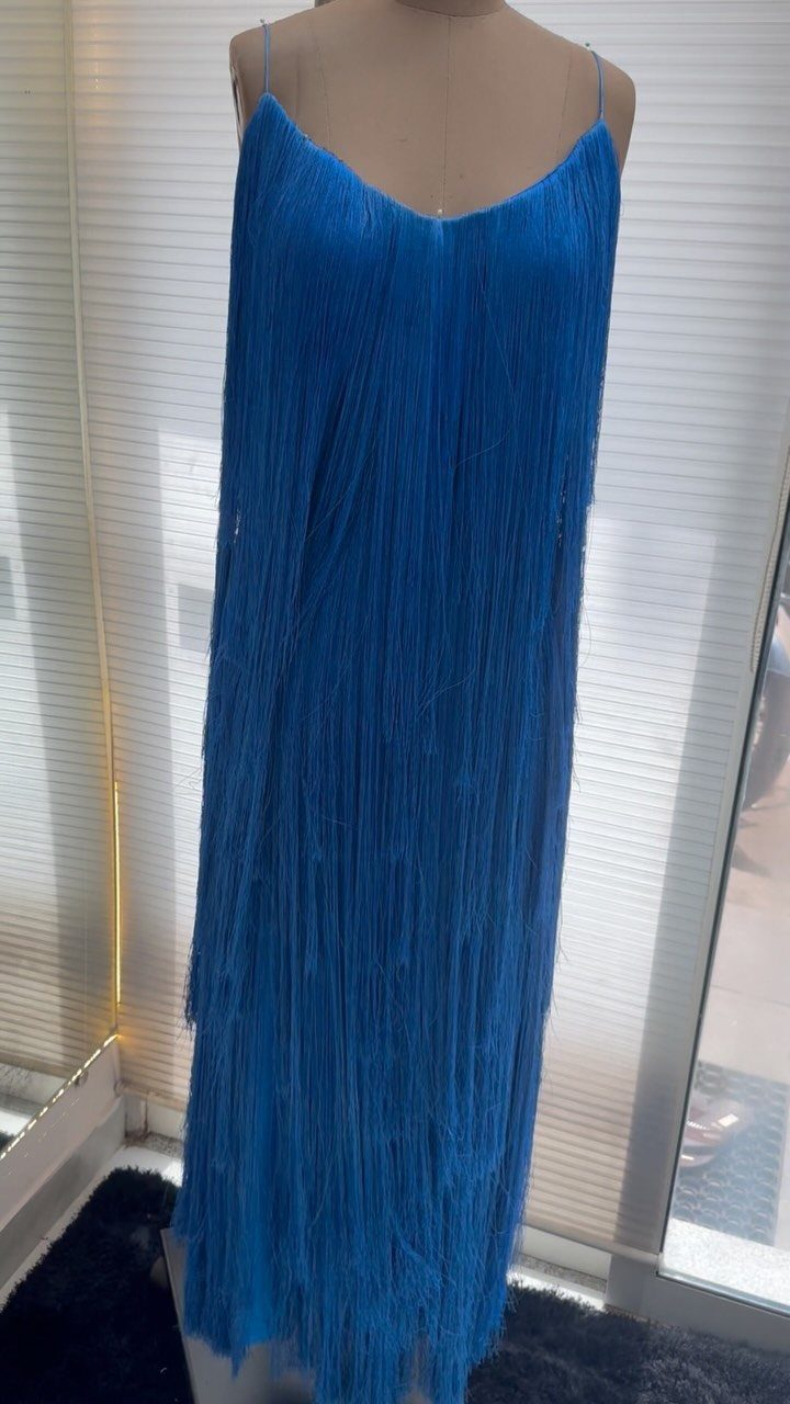 Royal blue tiered fringe dress on a mannequin against a white wall.
