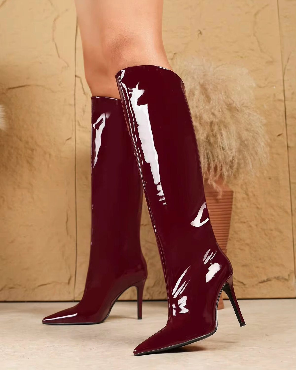 Glossy deep red patent leather high heel boots with pointed toes