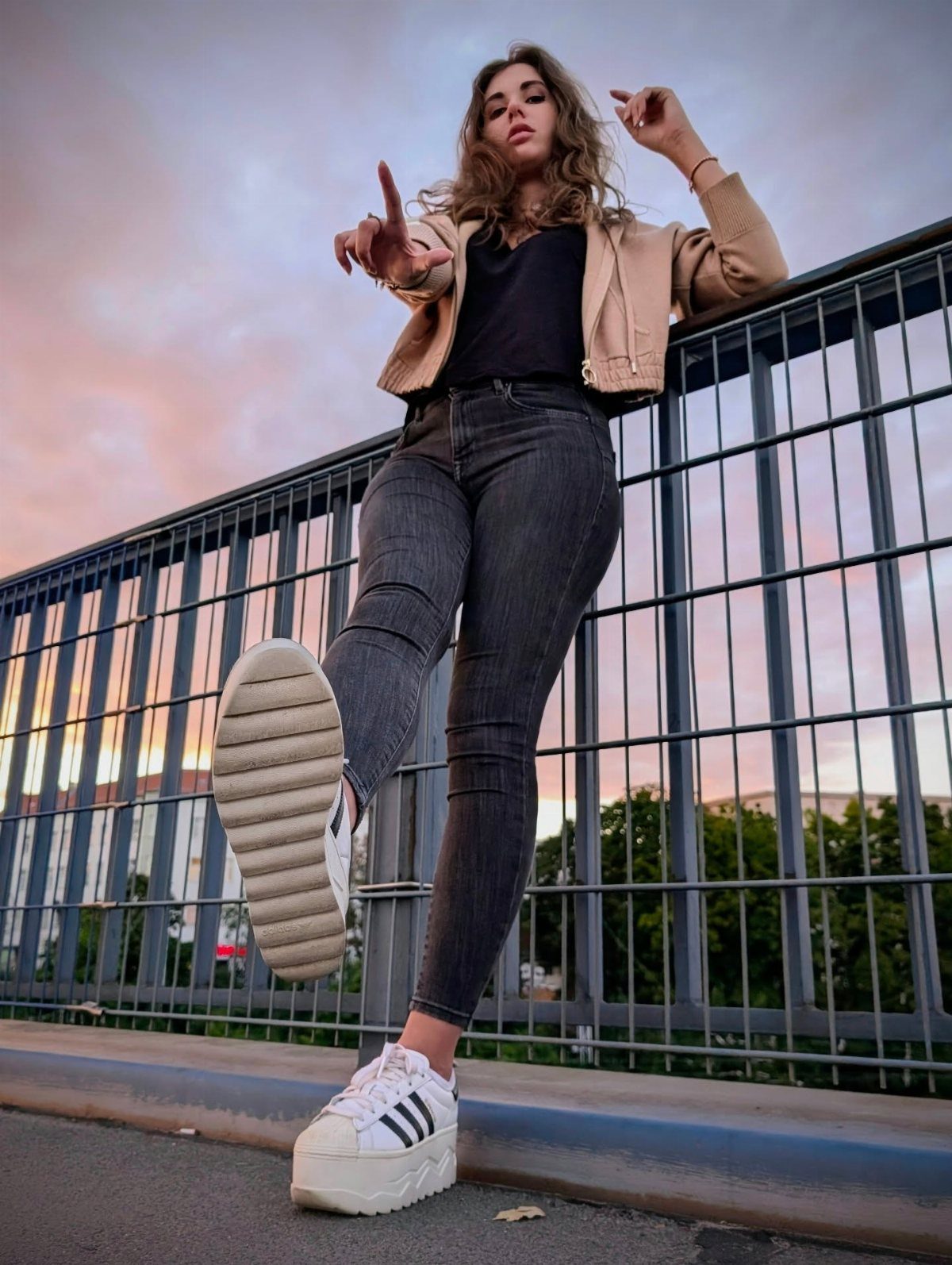 Adidas Superstar Up Wedge with 5 Outfit Ideas to Copy 2 Woman in grey jeans and white platform Adidas sneakers posing by a railing