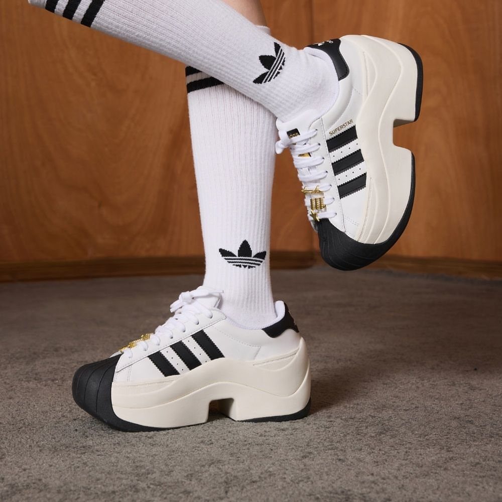 Adidas Superstar Up Wedge with 5 Outfit Ideas to Copy 3 White Adidas Superstar platform wedge sneakers with black stripes and gold chain details.