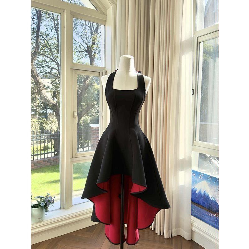 Black high-low dress with red lining on a white mannequin by a window
