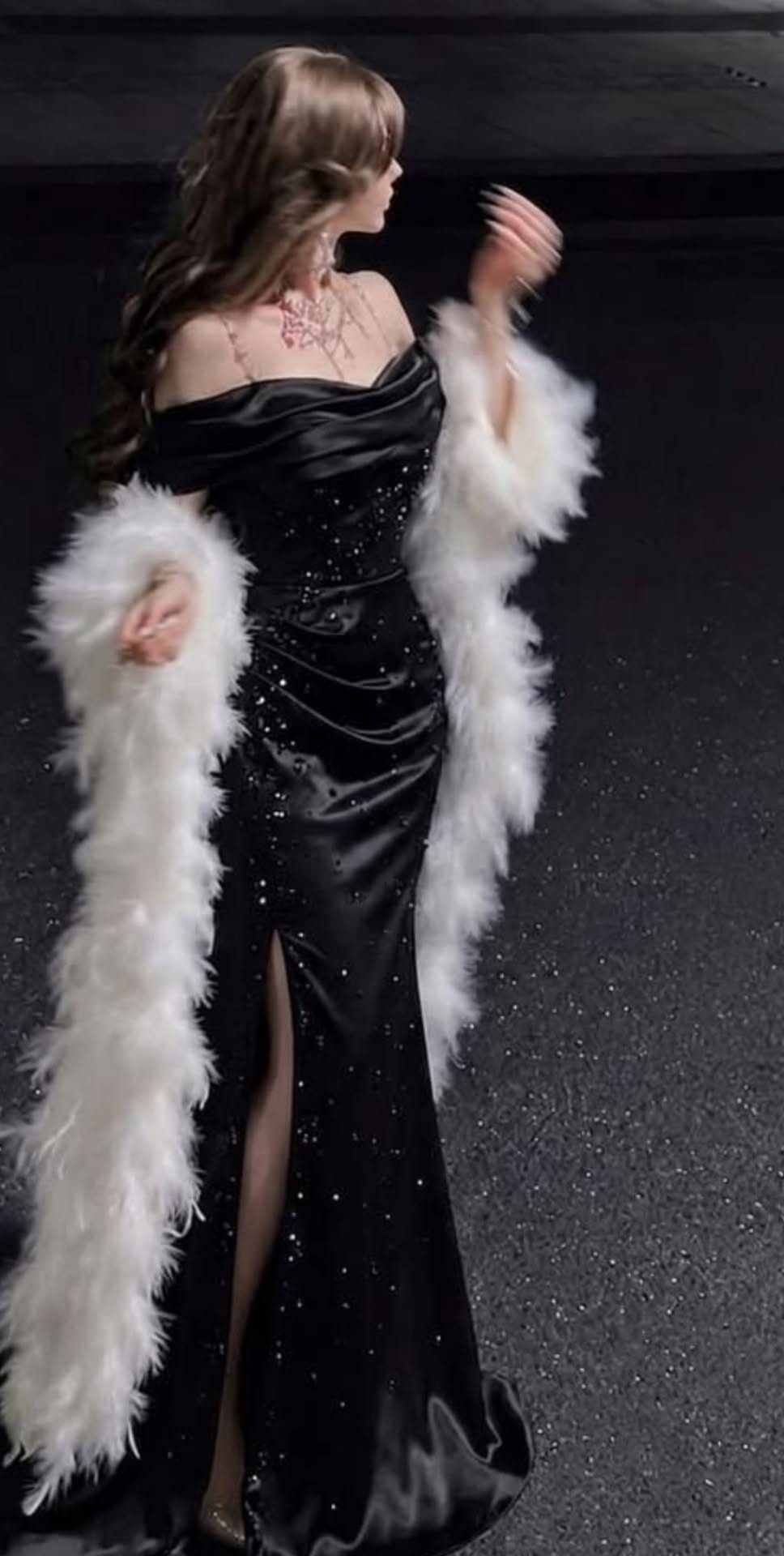 6 Ways to Wear a Black Dress with Fur Shawl 4 Woman in a black satin gown with a white fur shawl and high slit.