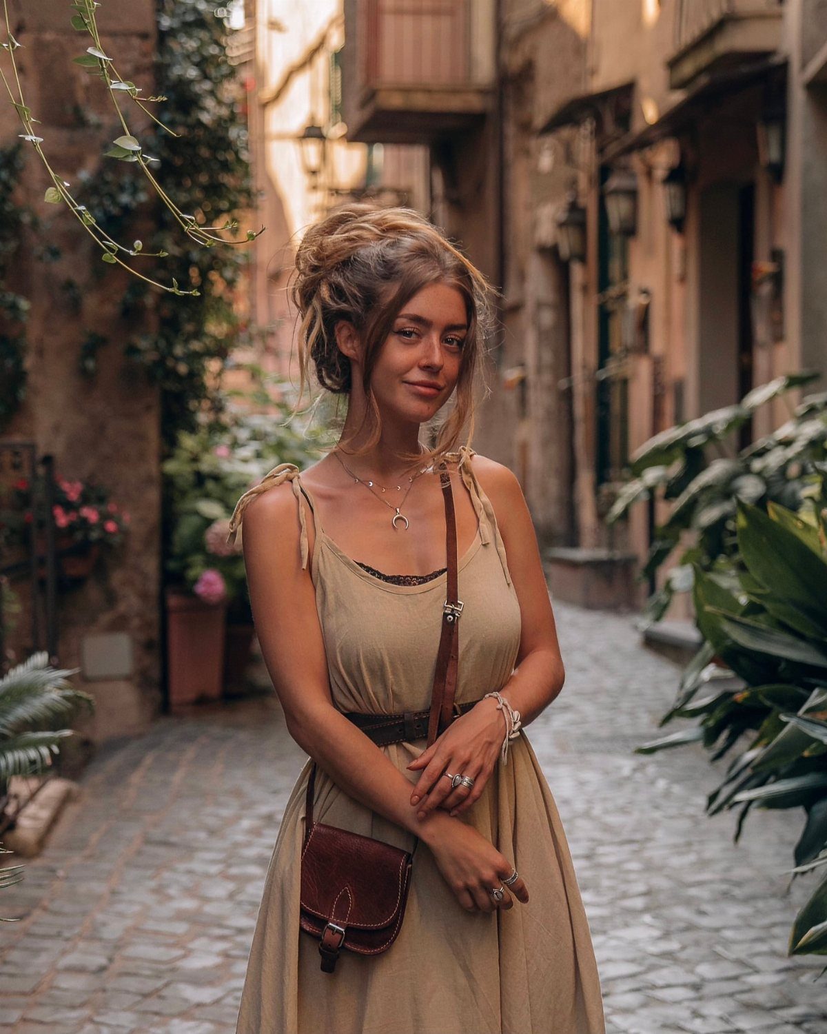 Bohemian Cream Dress Ideas: 9 Ways to Wear One 9 Woman in a cream sleeveless dress and brown bag on a cobblestone street