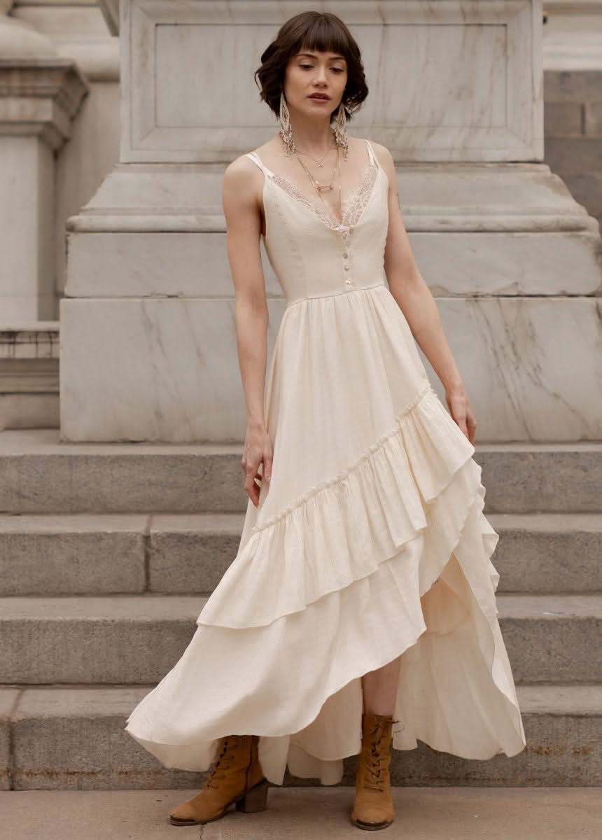 Boho Cream Dress Ideas: 7 Linen, Lace and Cotton Styles 3 Woman in a cream lace-trim maxi dress wearing brown lace-up ankle boots.