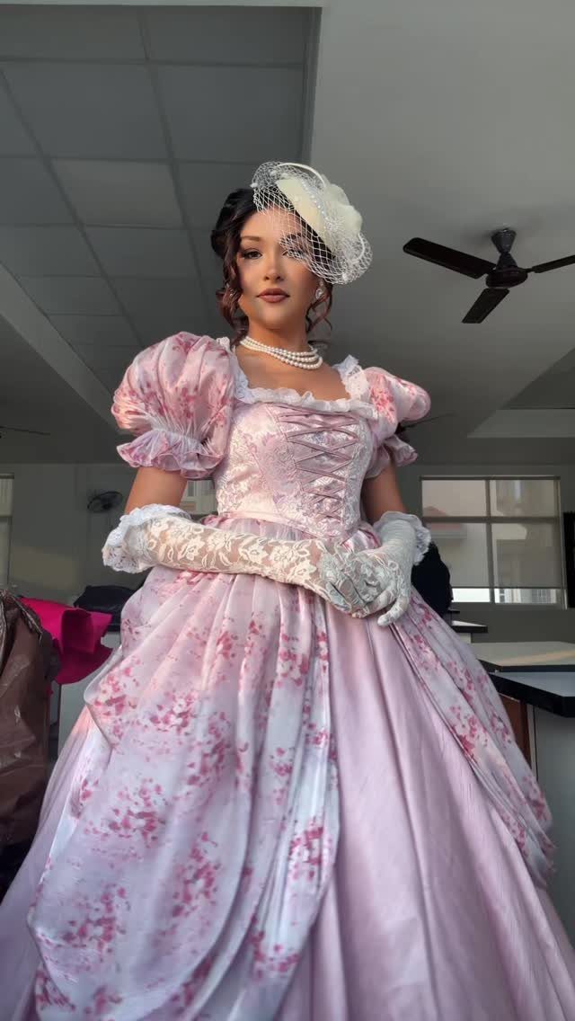 Woman in a pink floral Regency gown with a square neckline and puffed sleeves.