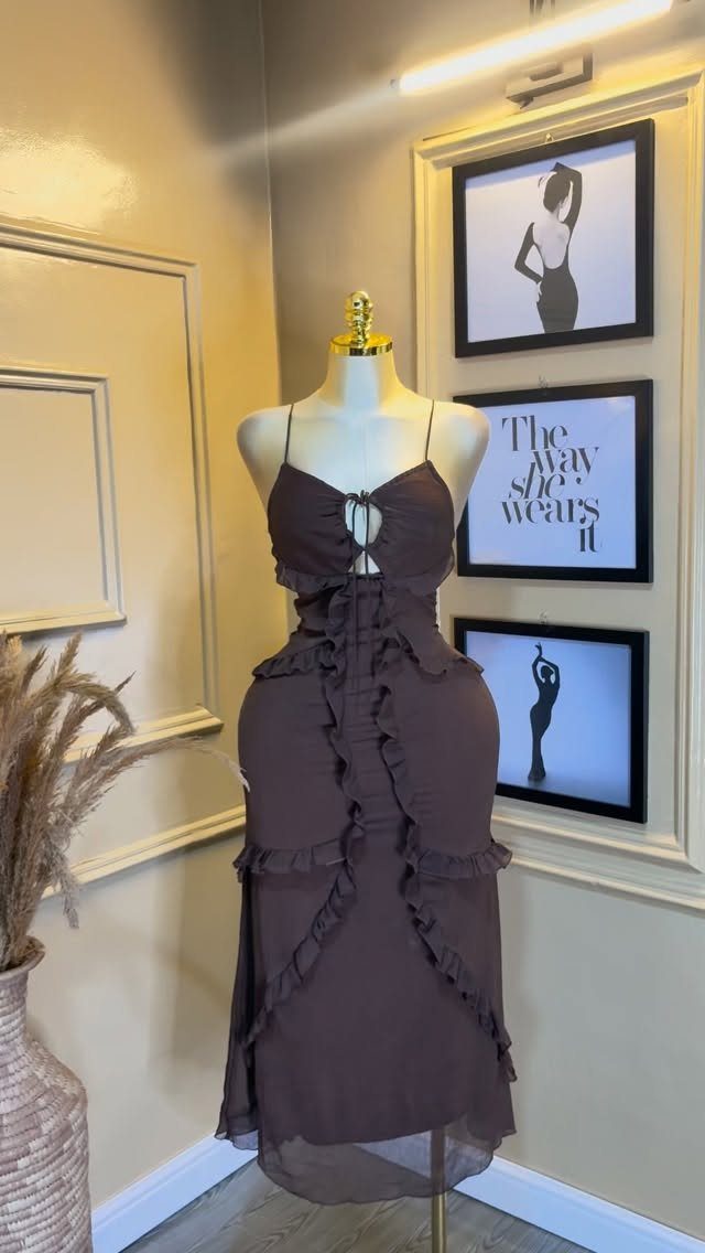 Dark brown maxi dress with ruffles displayed on a mannequin in a studio.