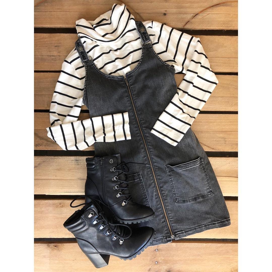 Dark grey denim mini dress over a striped turtleneck with black lace-up boots.