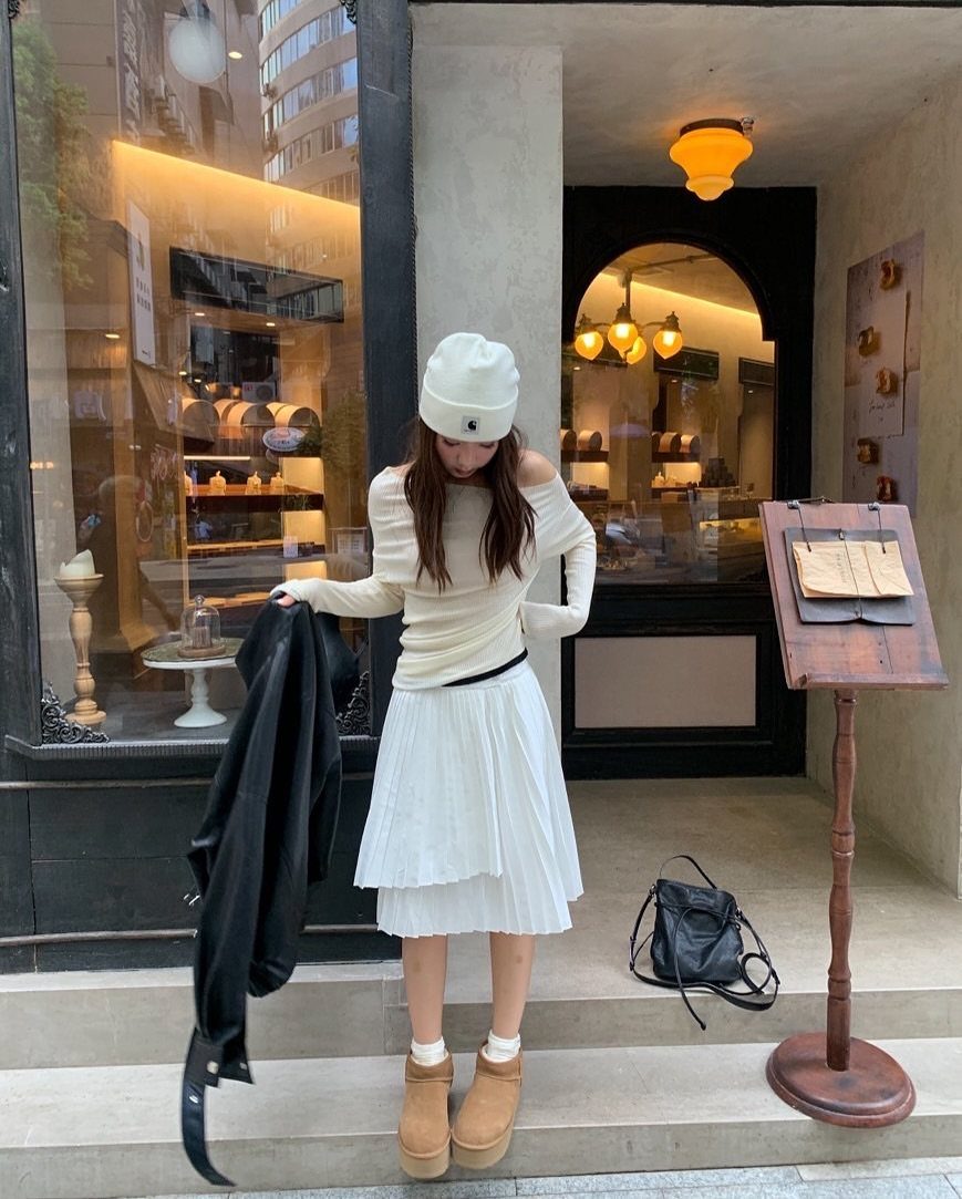 7 Different Types of Uggs for Every Season and Style 6 Woman wearing tan platform Ugg boots and white outfit standing outside a shop