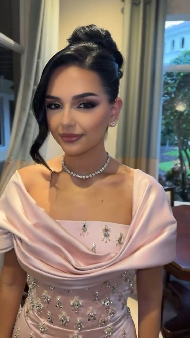 Woman in a pale pink formal dress with silver beading and diamond choker.