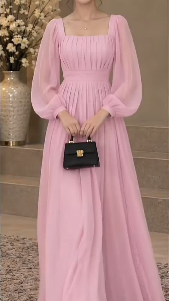 Person wearing a long light pink maxi dress with puff sleeves and black handbag