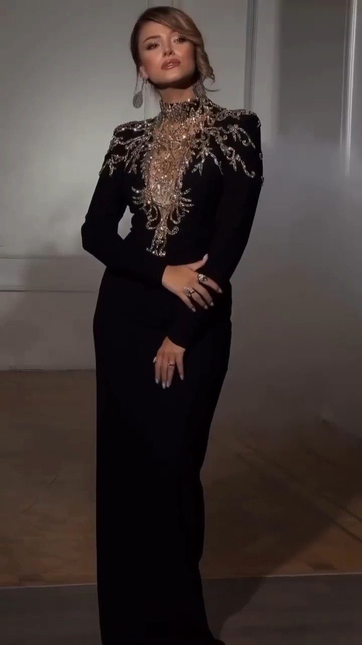 6 Elegant Long Sleeve Evening Dress Ideas for Formal Events 1 Woman in a black long sleeve evening gown with gold beaded bodice embroidery.