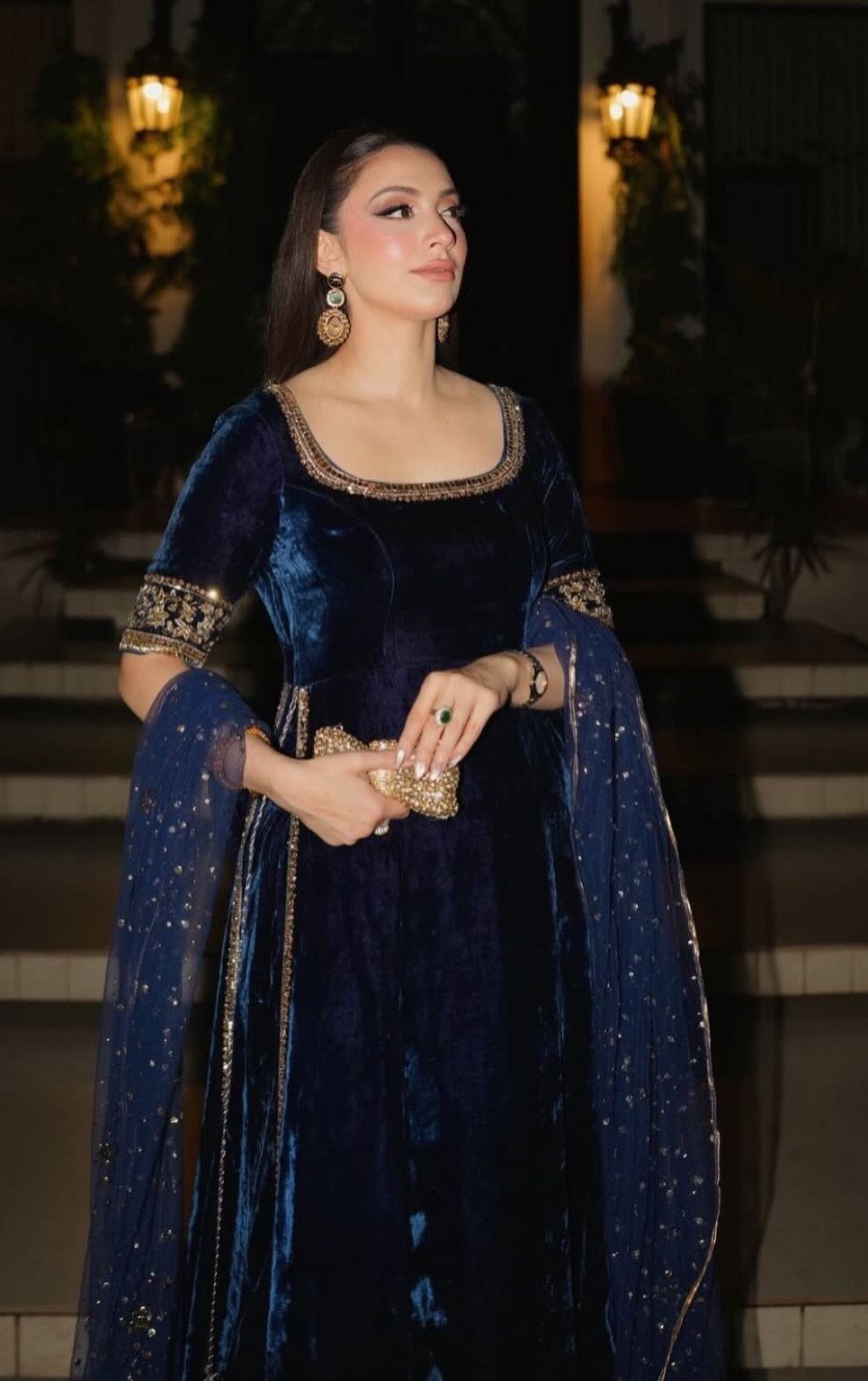 Woman in a navy blue velvet dress with gold embroidery and sheer dupatta
