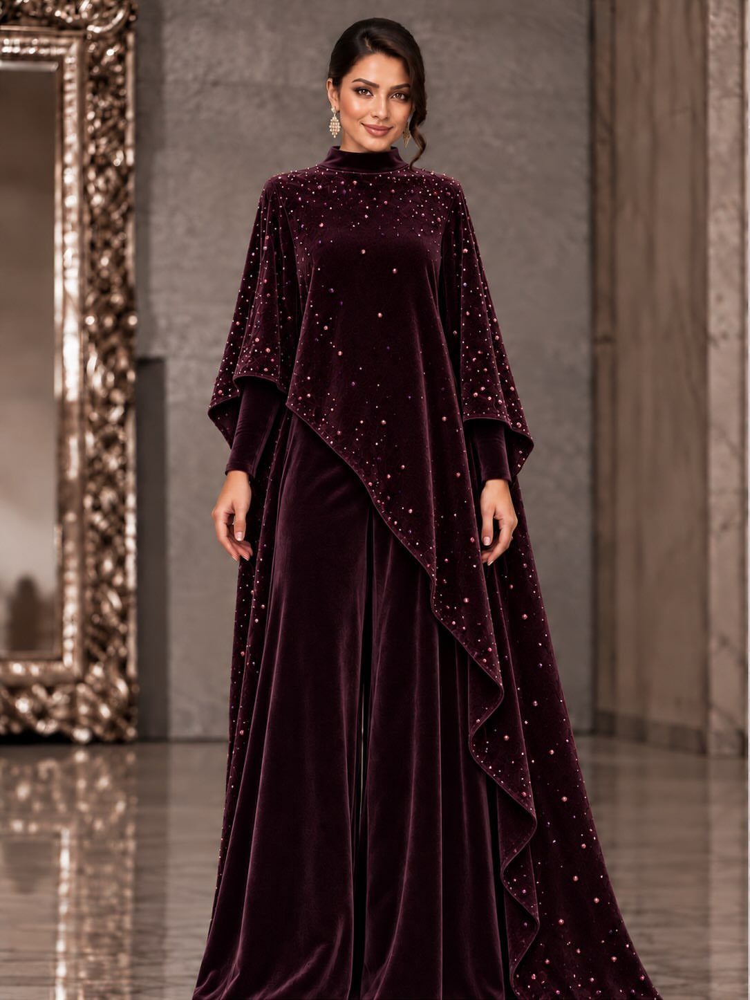 Woman in a high-neck burgundy velvet gown with sparkling embellishments and cape overlay.