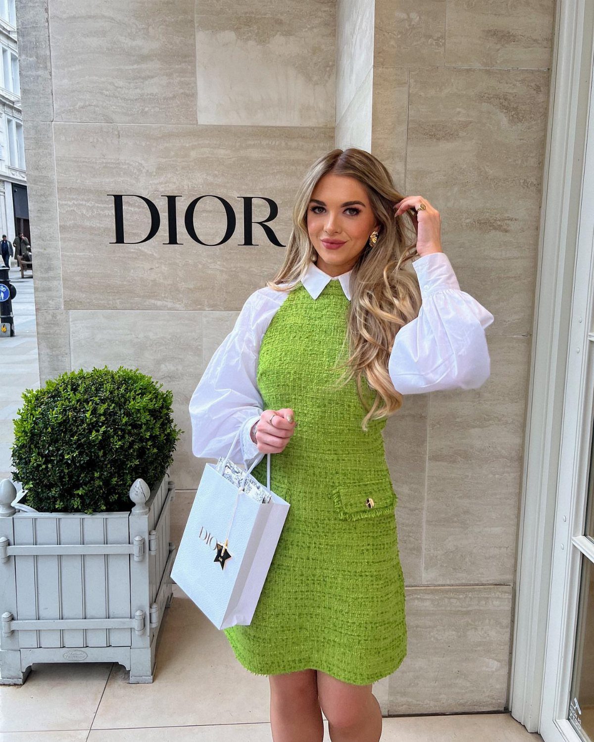11 Glitz Glam Outfit Ideas with Sequins, Fringe and Fur 4 Woman wearing a lime green tweed dress and white shirt outside a Dior store