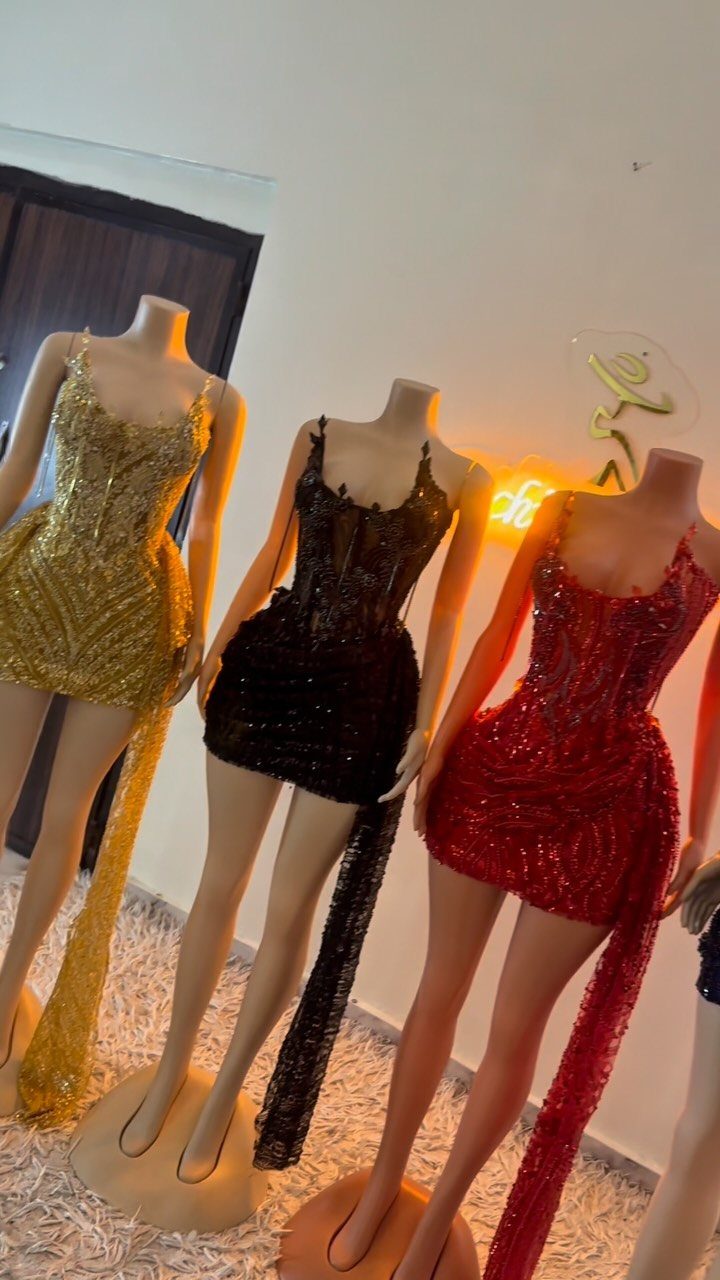 Three sequined mini dresses in gold, black, and red with long matching trains.