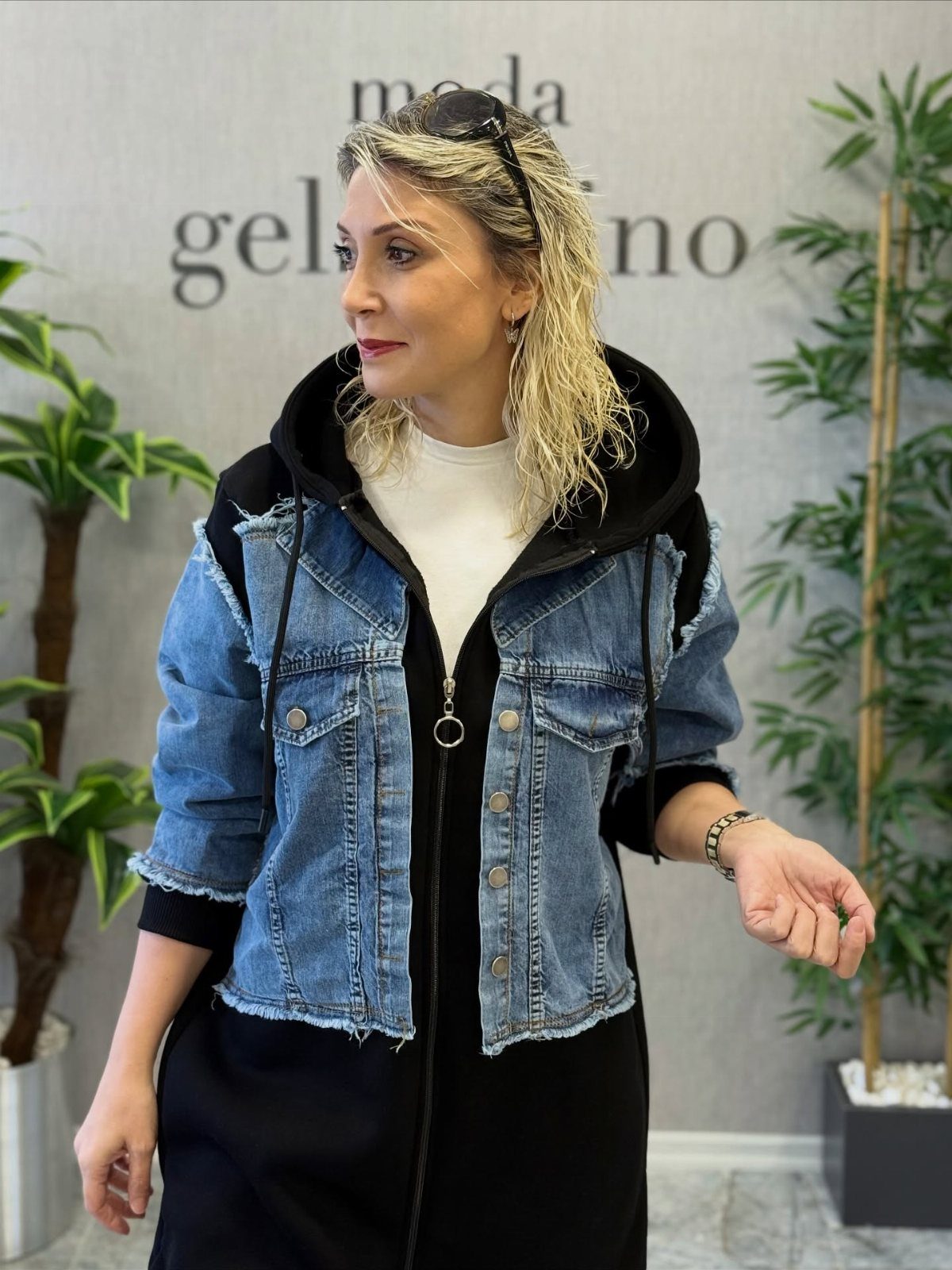 How to Style a Tunic: 9 Ideas From Jeans to Shorts 8 Woman wearing a cropped denim jacket over a long black tunic dress.