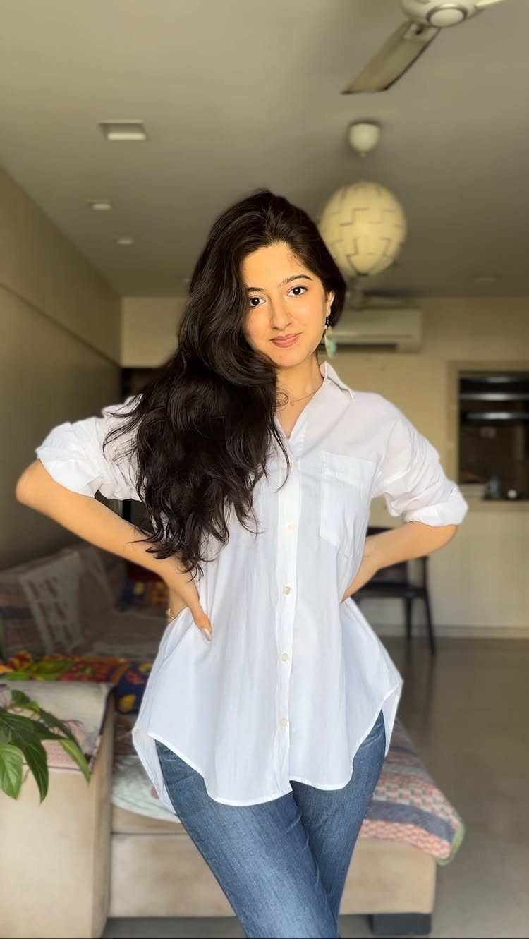 How to Style a Tunic: 9 Ideas From Jeans to Shorts 1 Woman wearing a long white tunic shirt paired with blue skinny jeans.