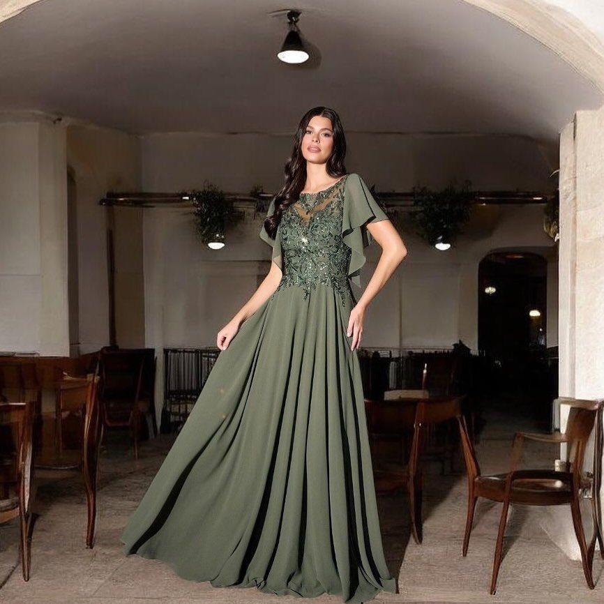 10 Luxury Dress for Wedding Guest Ideas and Styles 8 Woman in olive green floor-length gown with beaded lace bodice in rustic room