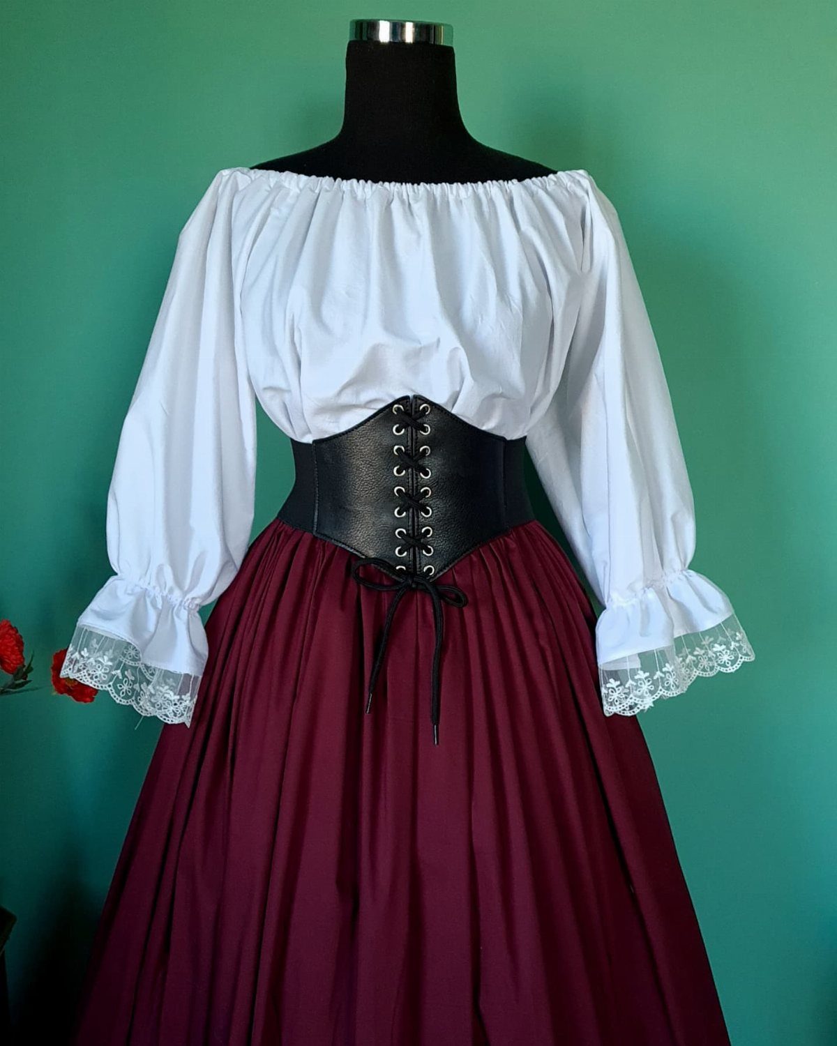 Medieval Period Dress: 12 Women's Styles and Looks 5 Mannequin wearing a white peasant blouse, black corset, and burgundy medieval skirt.