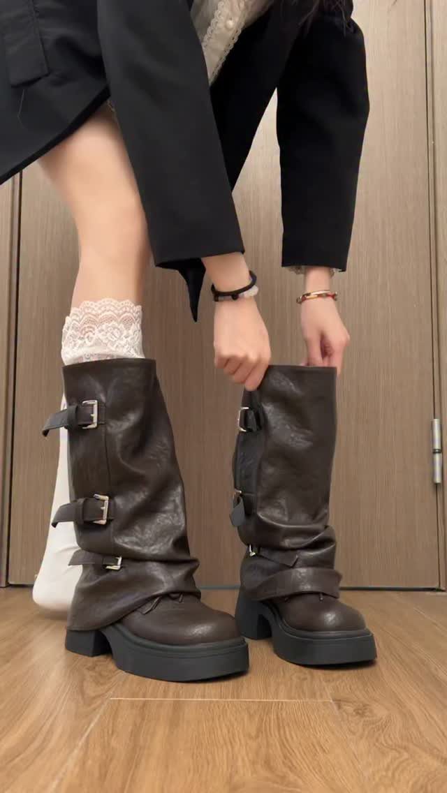 Dark brown leather mid-calf boots with chunky heels and buckle straps on feet.