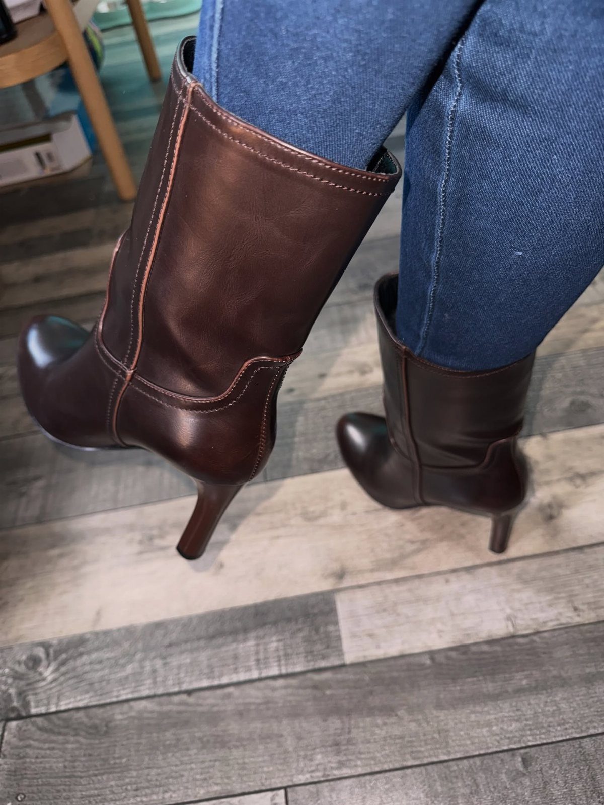 Dark brown leather mid-calf heel boots worn with blue denim jeans.