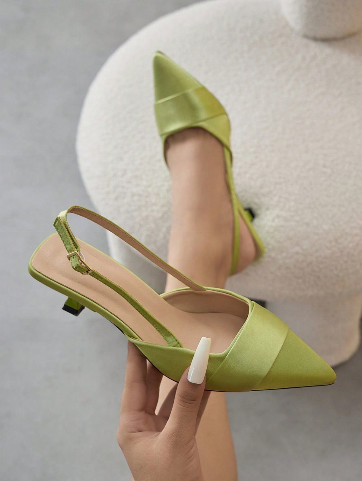 Lime green satin kitten heels with pointed toes and thin ankle straps.