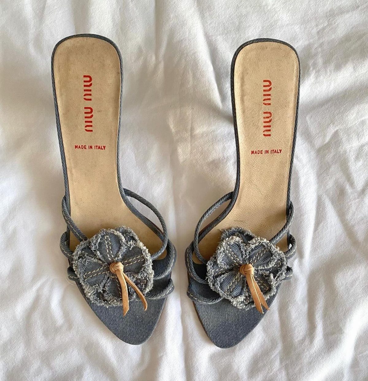 Miu Miu Kitten Heels: 7 Ideas for Every Outfit 1 Blue denim Miu Miu kitten heels with large fabric flowers on the toes.