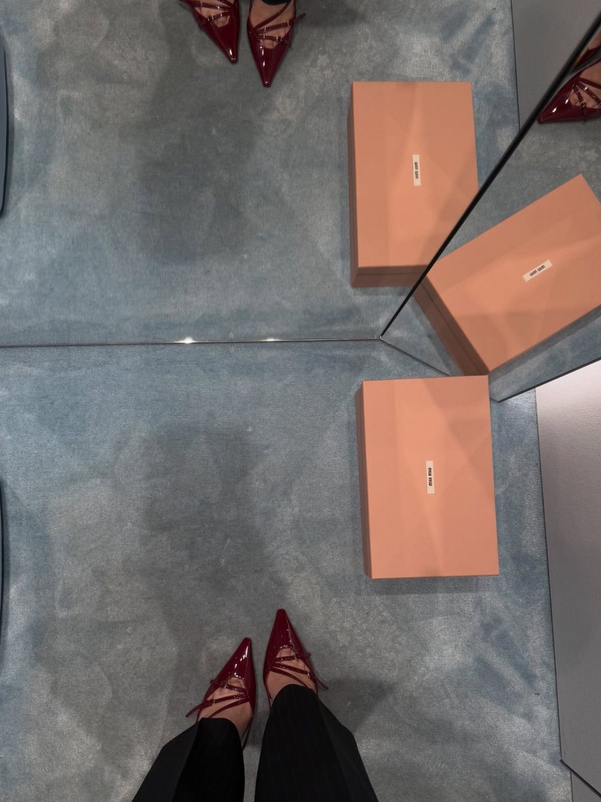 Miu Miu Kitten Heels: 7 Ideas for Every Outfit 5 Red patent leather Mary Jane kitten heels worn with black trousers on blue carpet.