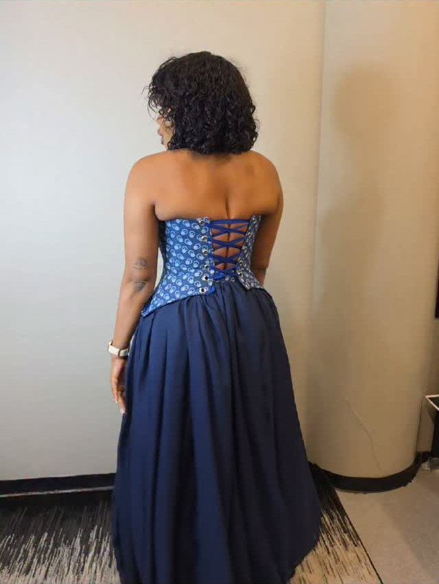 Navy Blue Ball Gown Ideas: 9 Styles From Tulle to Corset 6 Woman from behind wearing a navy blue gown with a lace-up corset bodice.