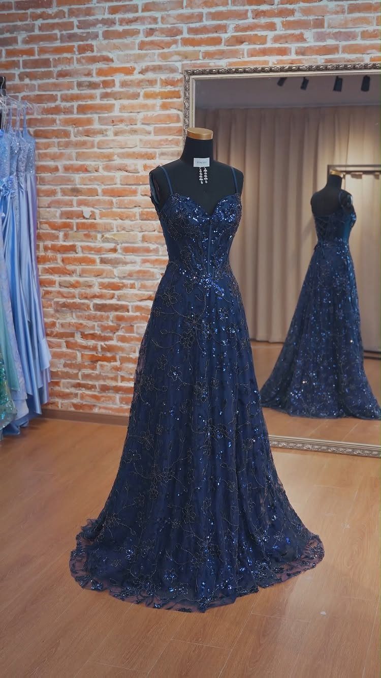 Navy Blue Ball Gown Ideas: 9 Styles From Tulle to Corset 9 Navy blue sequined ball gown on a mannequin against a brick wall background.