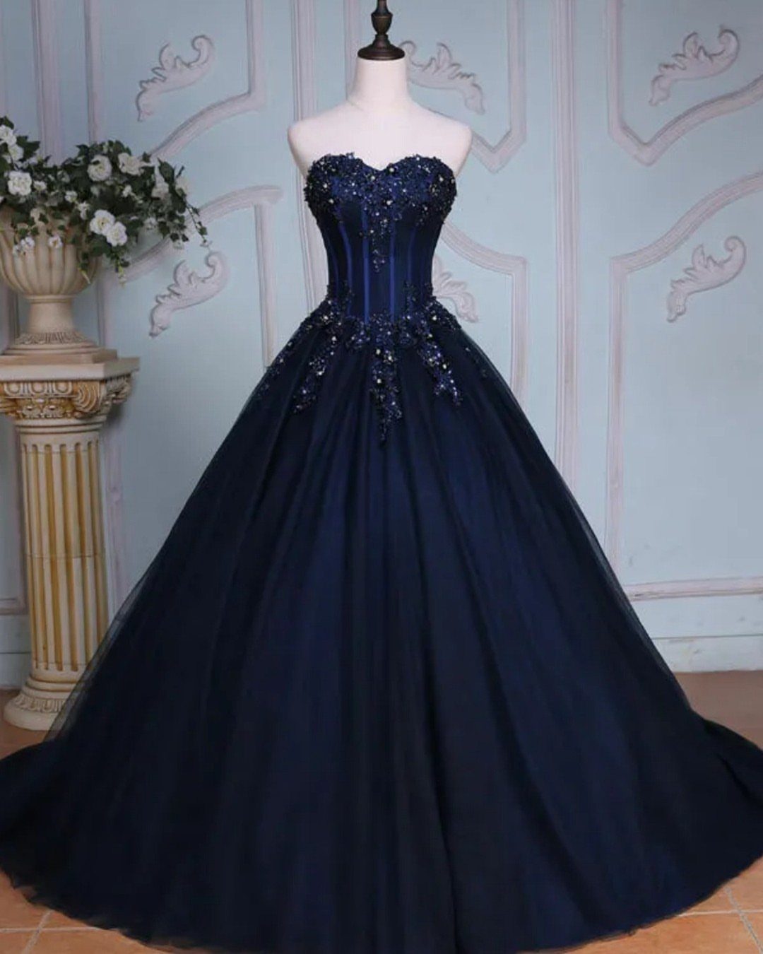 Navy Blue Ball Gown Ideas: 9 Styles From Tulle to Corset 4 Navy blue ball gown with sequined embellishments on a white mannequin.
