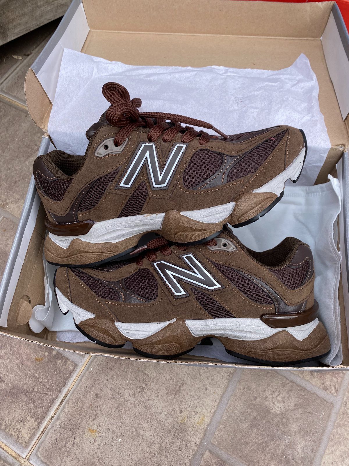 New Balance 9060 Marron Sneakers: 5 Ideas to Wear 4 Brown New Balance 9060 sneakers with white logos inside a cardboard shoebox.