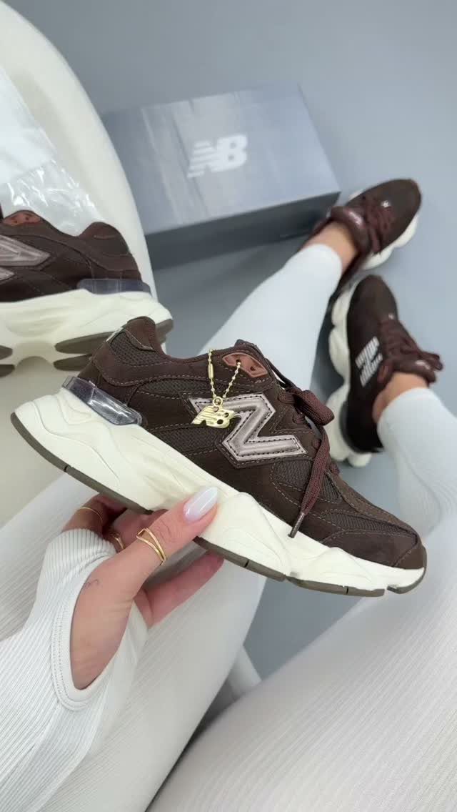 New Balance 9060 Marron Sneakers: 5 Ideas to Wear 5 Brown New Balance 9060 sneakers held by a person wearing white leggings.