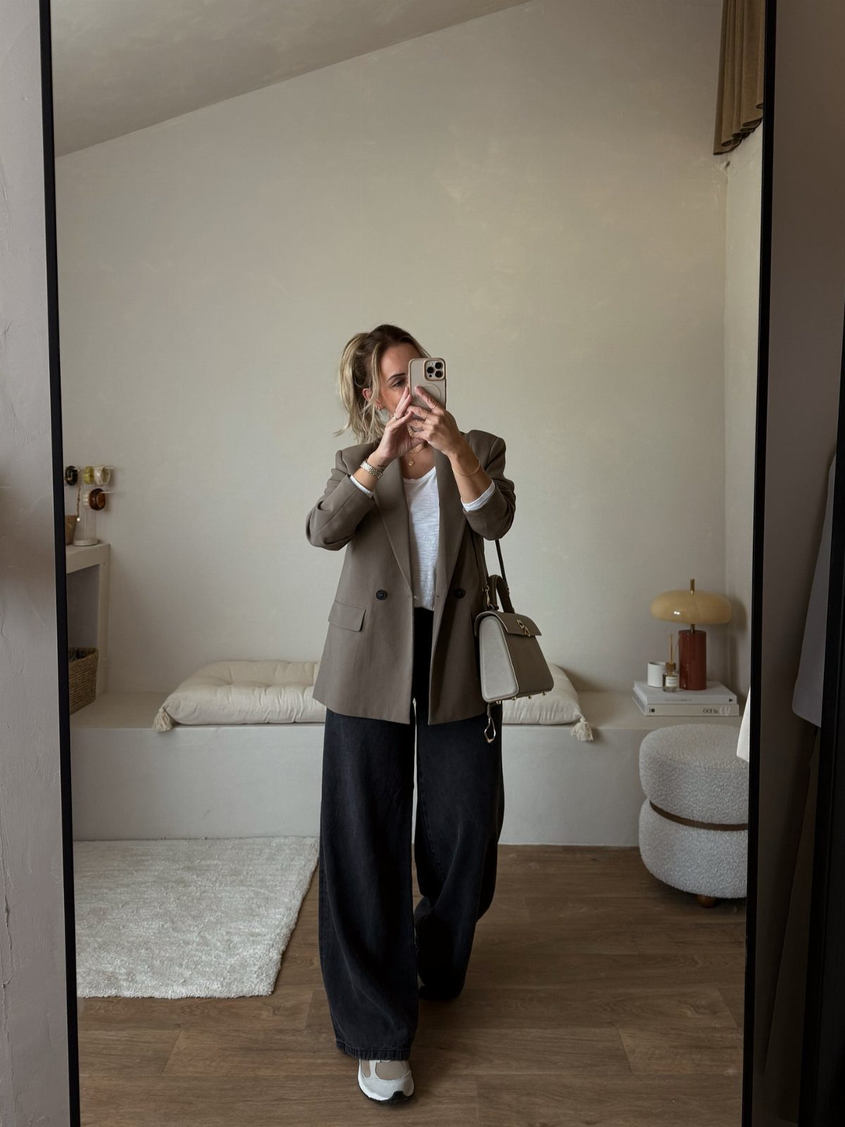 New Balance 9060 Sea Salt Moonbeam: 5 Outfit Ideas 4 Woman in taupe oversized blazer and black wide-leg trousers wearing white chunky sneakers.