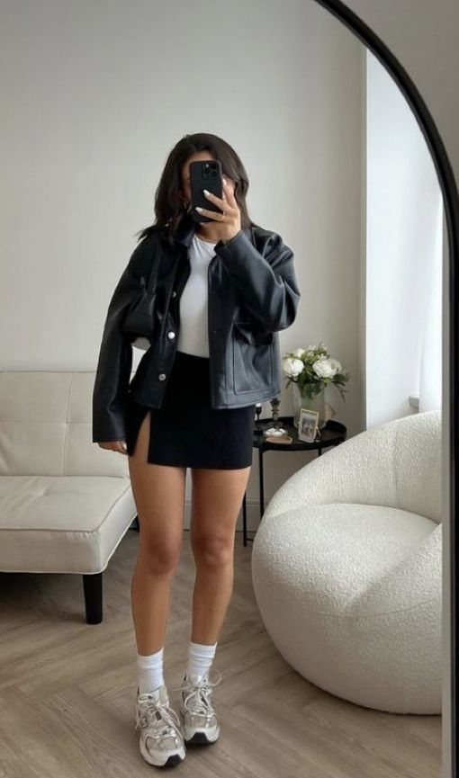 New Balance 9060 Sea Salt Moonbeam: 5 Outfit Ideas 3 Woman wearing a black mini skirt and chunky cream sneakers for a feminine look.