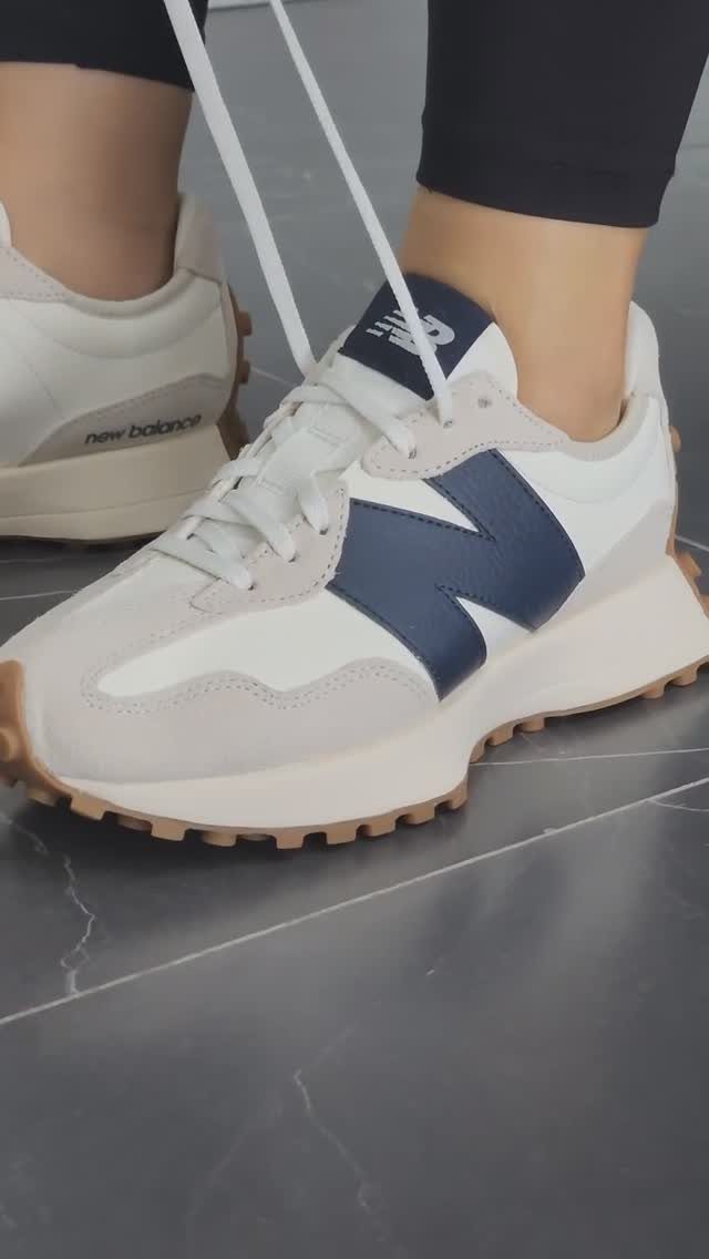 White and grey New Balance 327 sneakers with navy logo and tan soles.