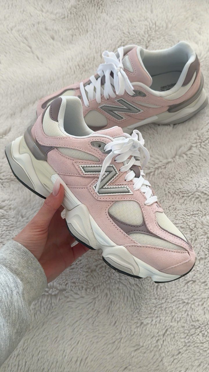 Pink New Balance 9060 sneakers with chunky white soles on white fluffy rug