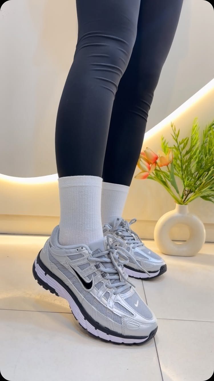 Nike Balance Shoes: 8 Sneaker Ideas for Women 7 Silver Nike athletic sneakers worn with white socks and black leggings.