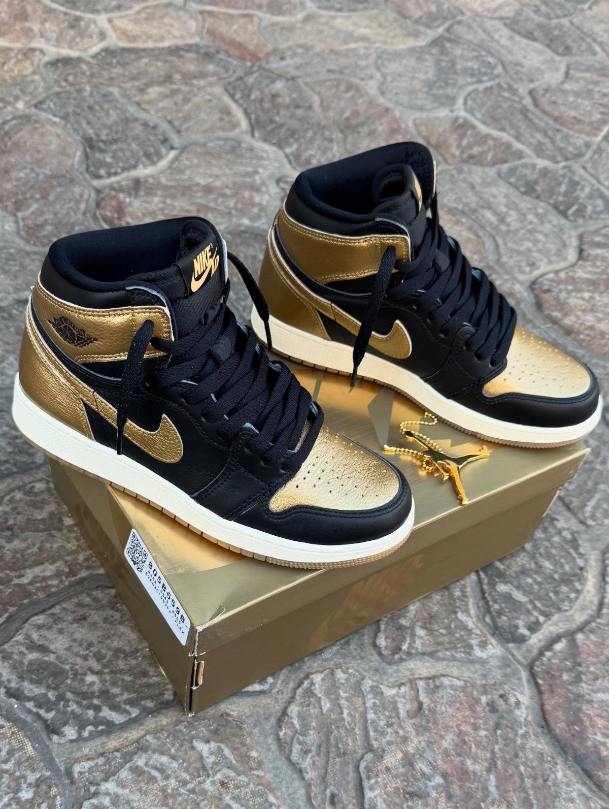 Nike Jordan Sneakers for Women: 12 Pairs to Know 2 Black and metallic gold high-top sneakers sitting on a gold shoe box.