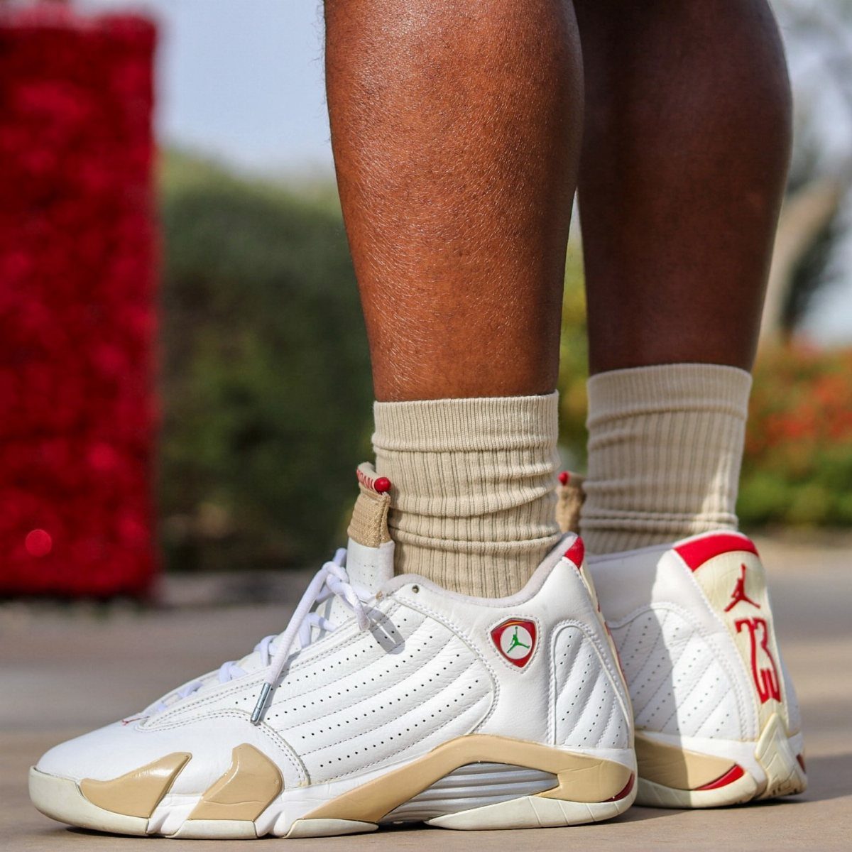 Nike Jordan Sneakers for Women: 12 Pairs to Know 5 White and cream Air Jordan 14 sneakers with red accents on a person.