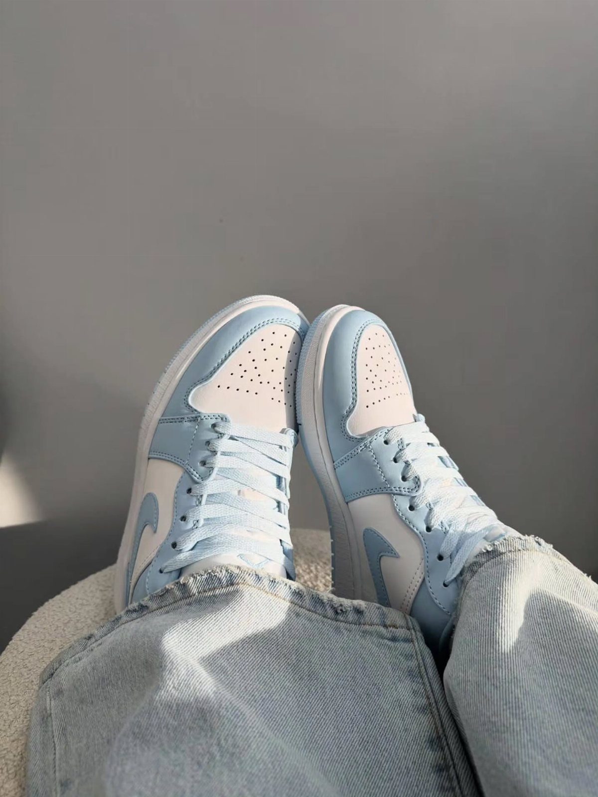 Nike Jordan Sneakers for Women: 12 Pairs to Know 12 Light blue and white high-top sneakers worn with light-wash denim jeans.