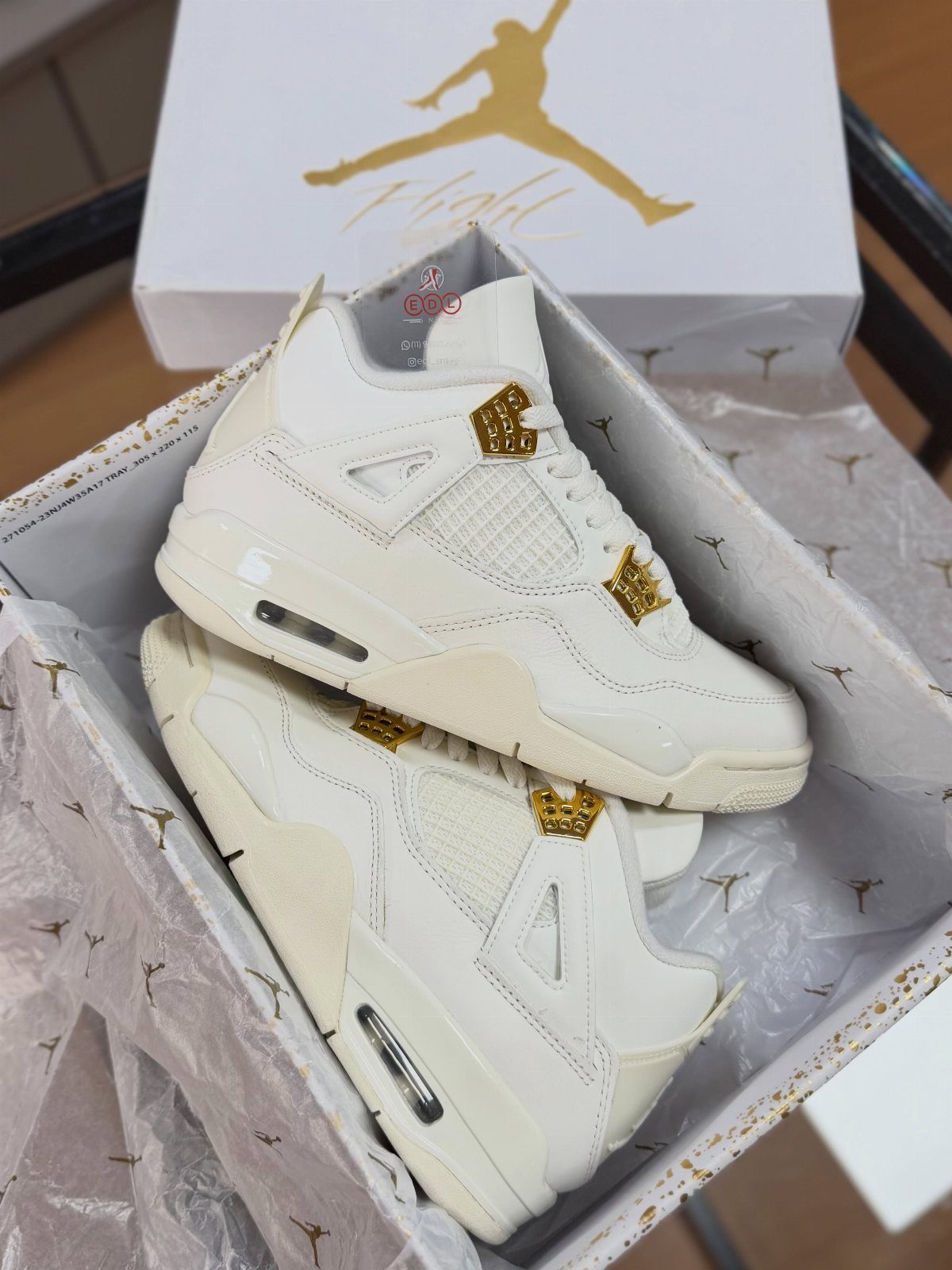 Nike Jordan Sneakers for Women: 12 Pairs to Know 8 White Air Jordan 4 sneakers with gold accents inside a branded shoe box.