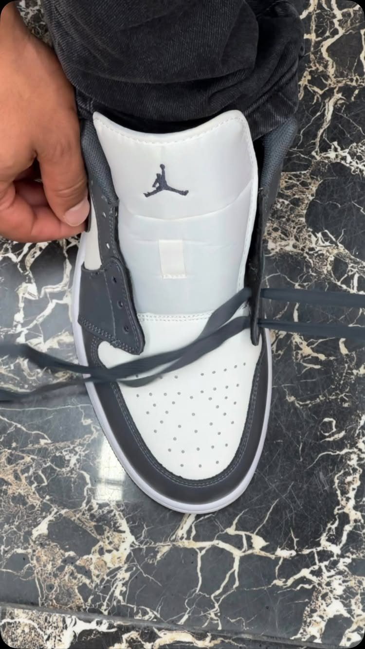 Nike Jordan Sneakers for Women: 12 Pairs to Know 6 White and grey Air Jordan 1 sneaker on a black marbled floor