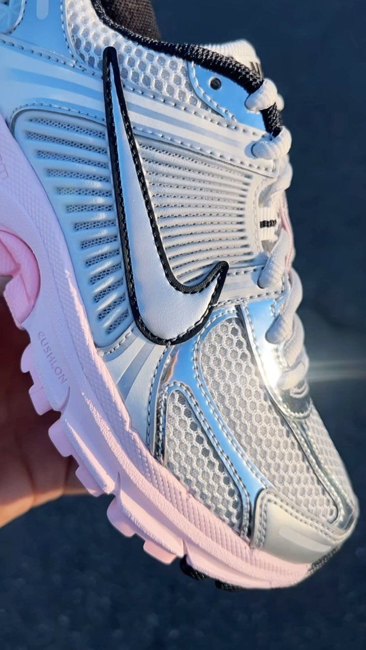 White and silver Nike sneaker with pink sole and metallic accents.